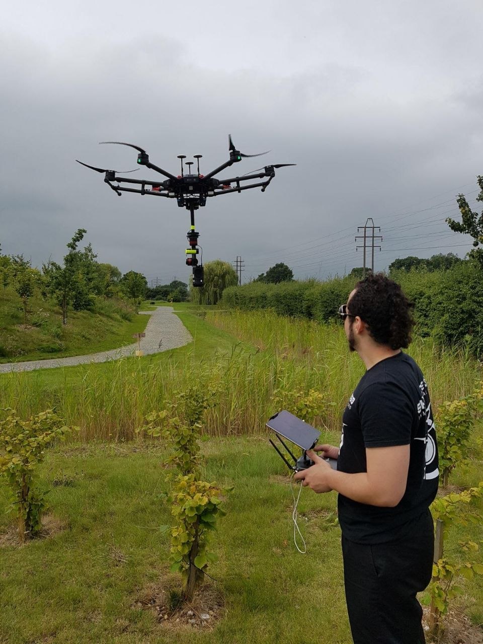 Drone pilot controlling heavy-lift drone in UK countryside